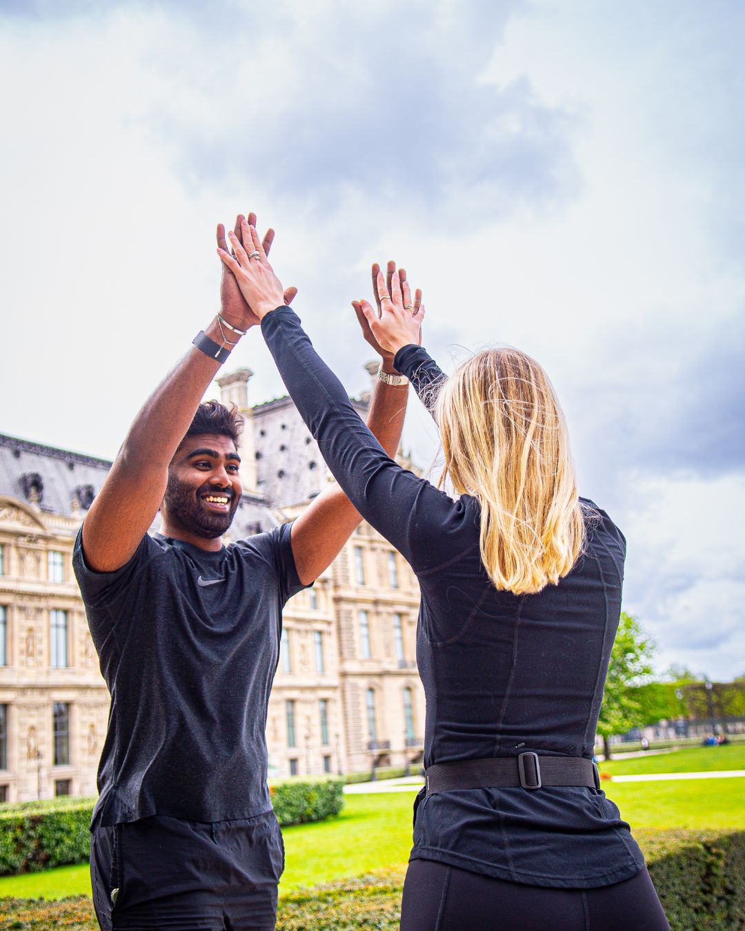 Deux joueurs se tapent dans la main devant le Louvre, à l'arrivée d'un parcours.